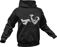 Load image into Gallery viewer, Astronaut playing with paper plane while floating in space printed on a black hoodie