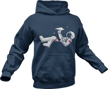 Load image into Gallery viewer, Astronaut playing with paper plane while floating in space printed on a blue hoodie